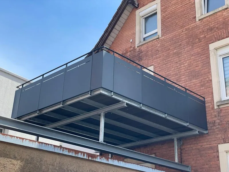 Anbaubalkon in Anthrazit mit Blechfüllung an einem Backsteinhaus