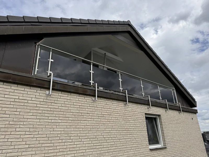 Edelstahlgeländer mit getöntem Glas im Dachgiebel