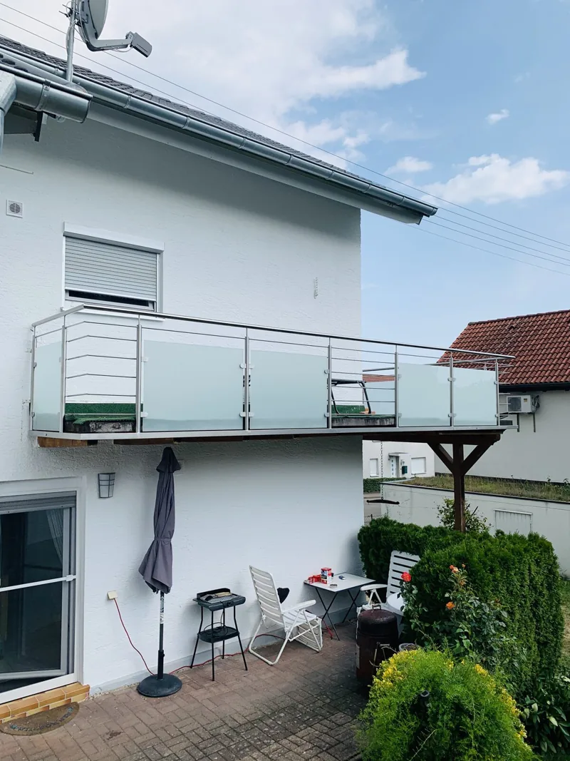Edelstahlgeländer mit satiniertem Glas an einem langen Anbaubalkon