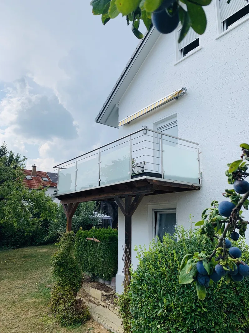 Edelstahl-Glasgeländer an einem Balkon mit Holzunterkonstruktion