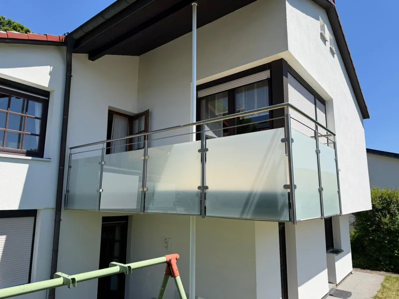 Balkongeländer aus Edelstahl mit satiniertem Glas an einem Wohnhaus
