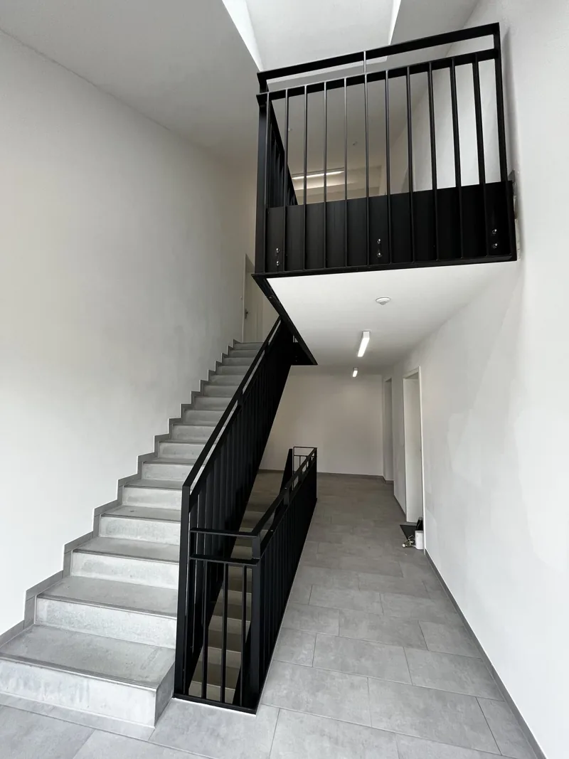 Schwarzes Stabgeländer im Treppenhaus eines Neubaus
