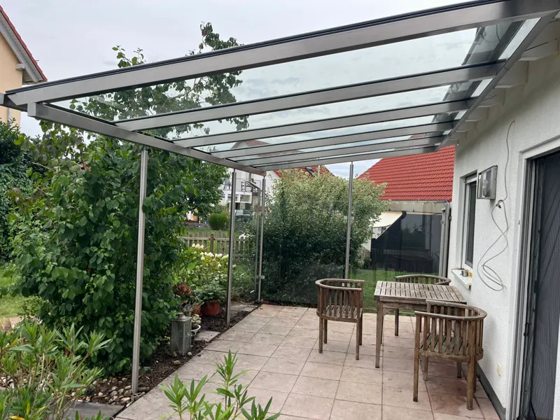 Edelstahl-Terrassenüberdachung mit Glasdach im Garten